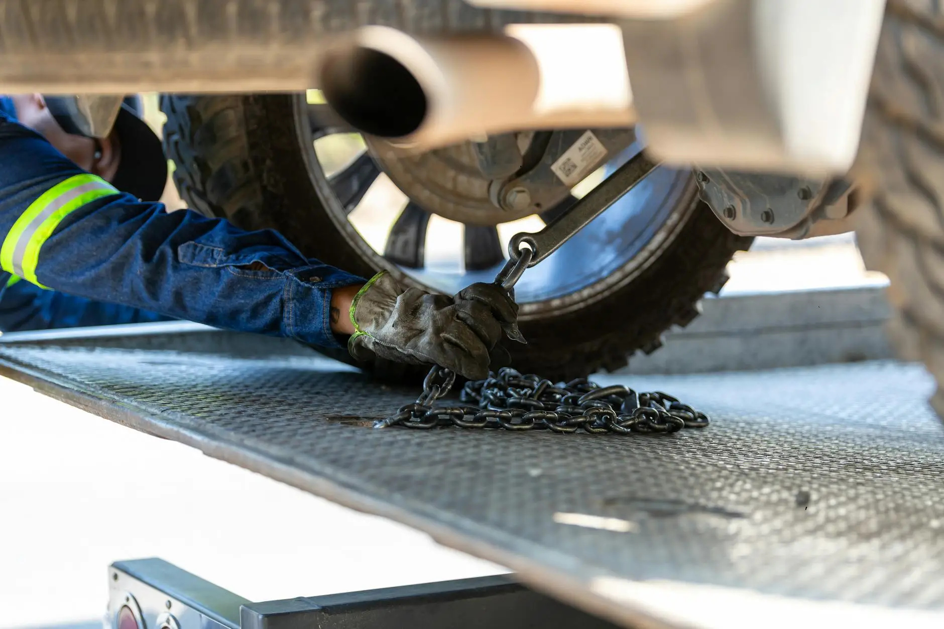 An Iron Wheel Towing operator safely securing a vehicle onto a flatbed tow truck in Oconomowoc, Wisconsin.